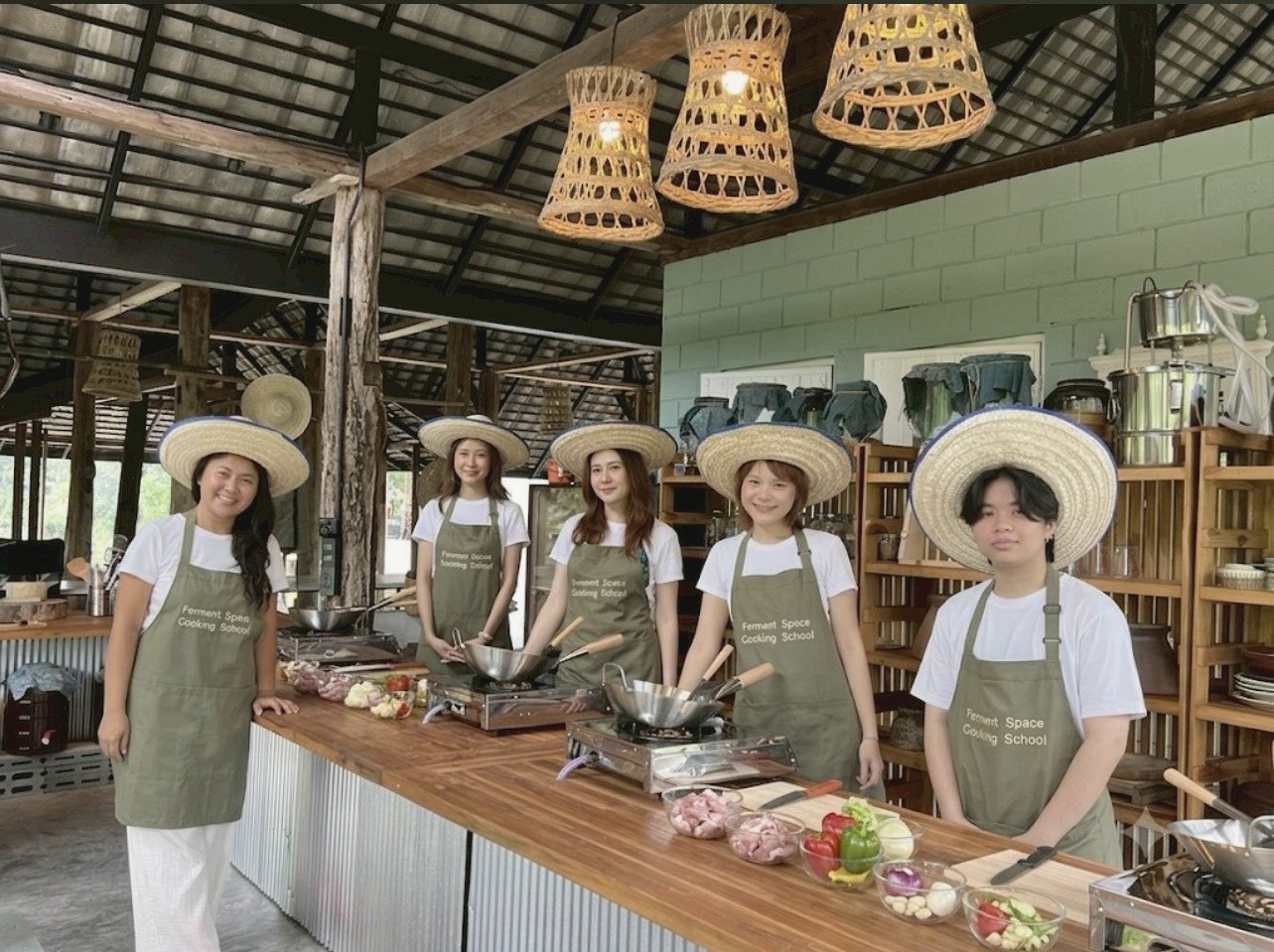Ferment Space students in branded aprons and hats at the cooking counter